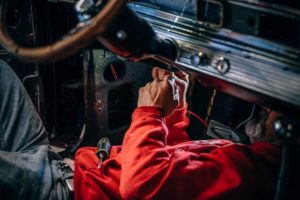 Mecánico trabajando en el interior de un coche.