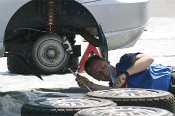 man working on tires by a car