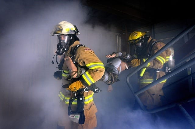 bombeiro entrando em um prédio em chamas com fumaça