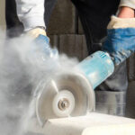 worker cutting engineered stone slab being exposed to harmful dust