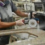 Worker cutting artificial stone countertop material and generating airborne silica dust.